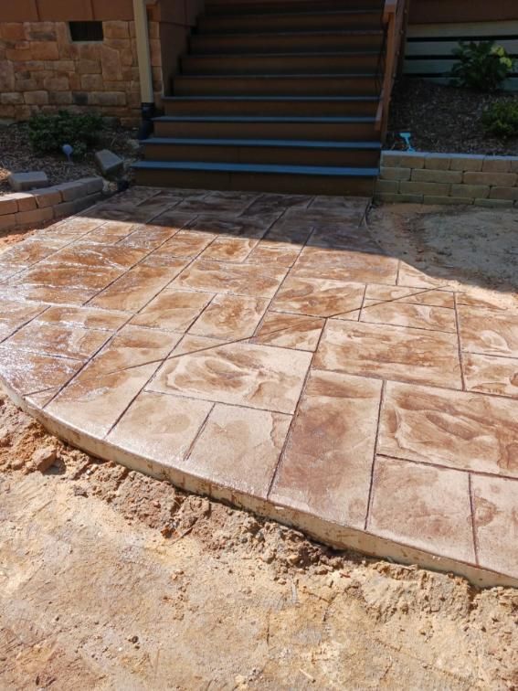 Stamped concrete patio with stone pattern leading to wooden stairs. Stamped concrete patio with stone pattern leading to wooden stairs.