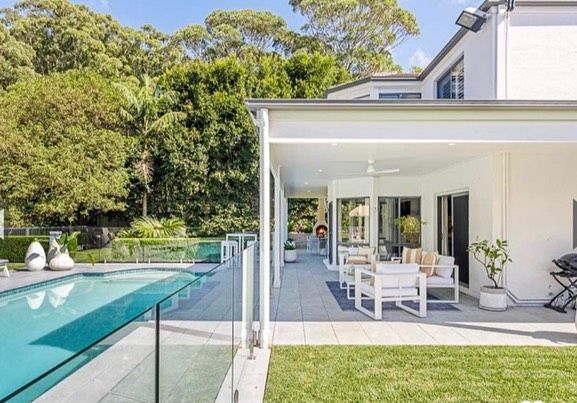 A Large White House With a Swimming Pool in the Backyard — D & J Saverino Painting & Decorating Pty Ltd In Fairy Meadow, NSW