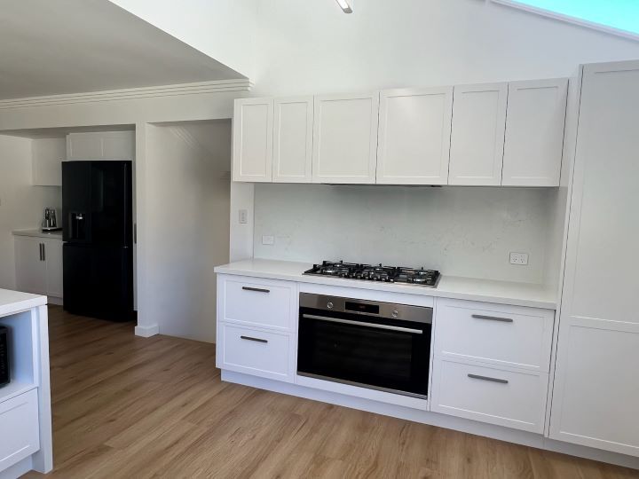 A kitchen with white cabinets and a stove top oven — D & J Saverino Painting & Decorating Pty Ltd In Fairy Meadow, NSW