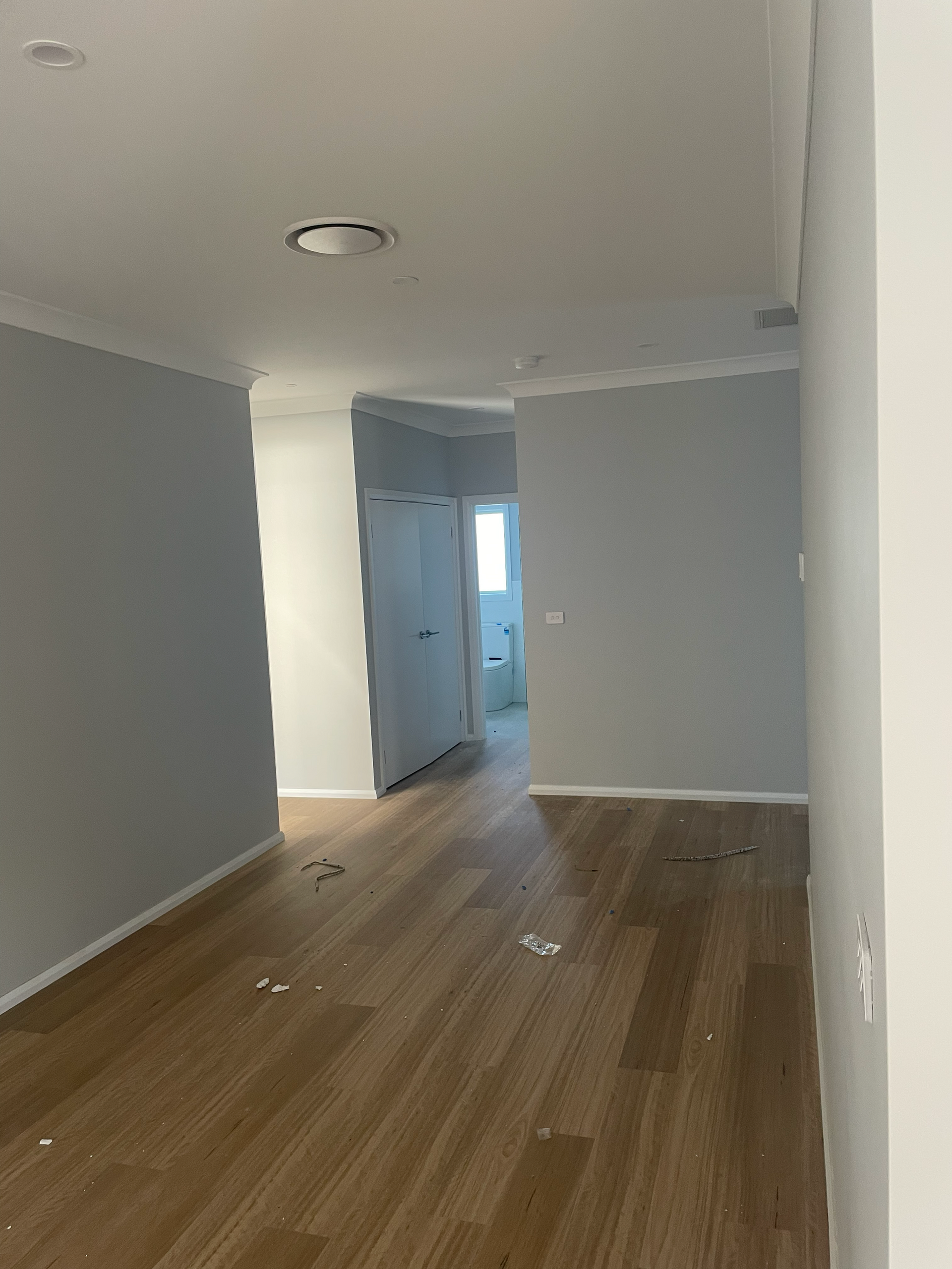 An empty room with hardwood floors and white walls — D & J Saverino Painting & Decorating Pty Ltd In Fairy Meadow, NSW
