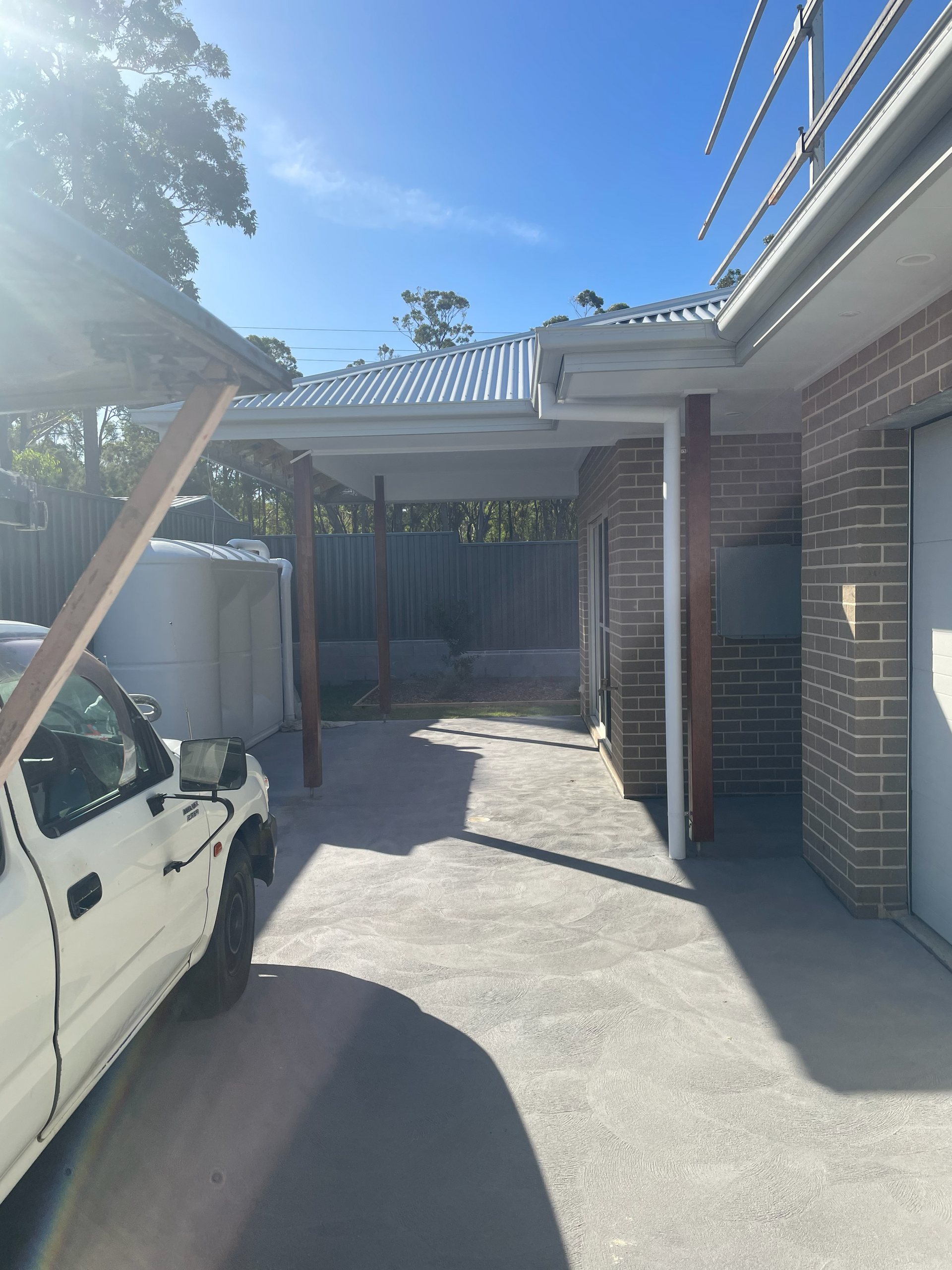 A white truck is parked in front of a brick house — D & J Saverino Painting & Decorating Pty Ltd In Fairy Meadow, NSW