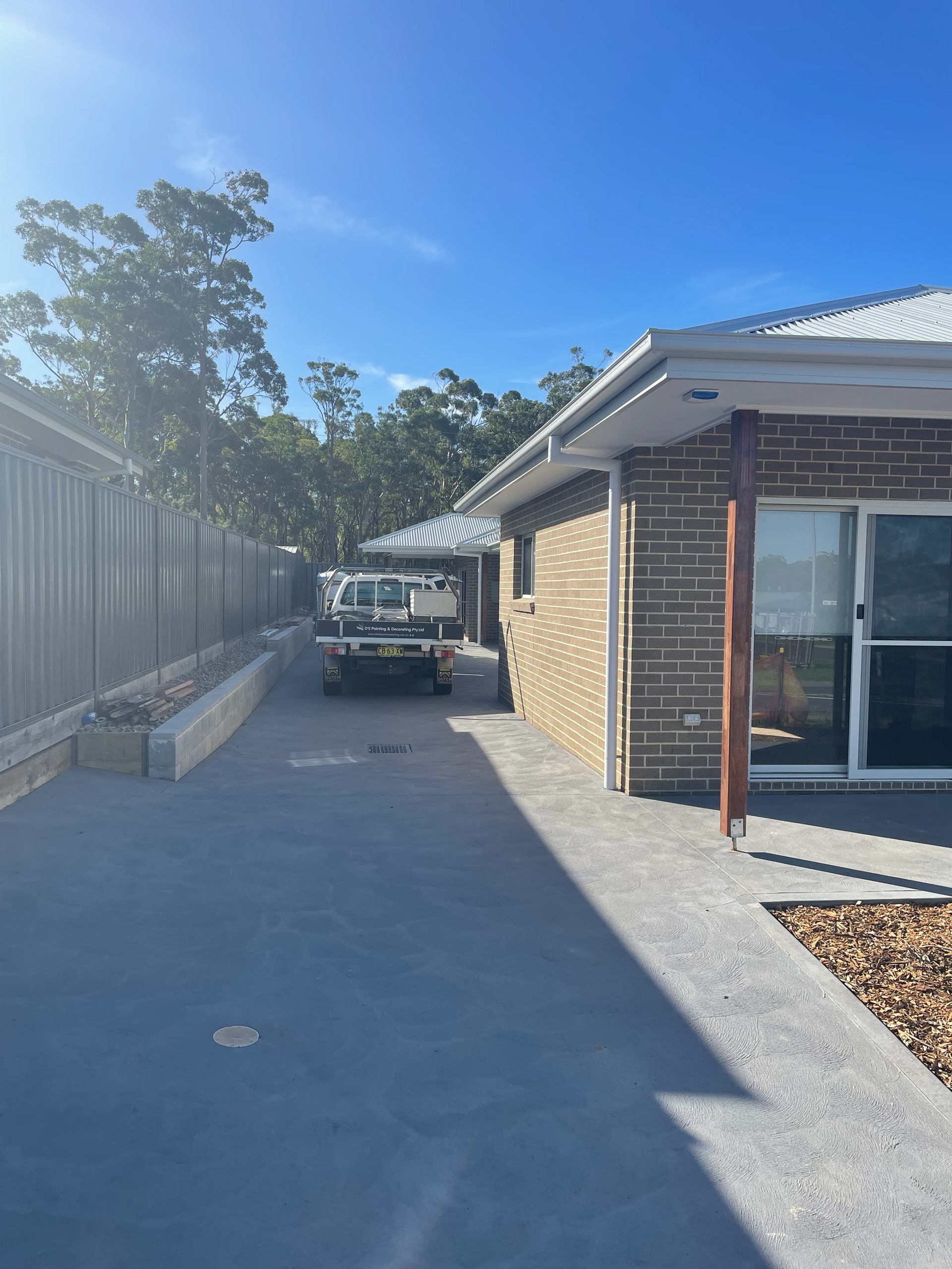 A truck is parked in front of a brick house — D & J Saverino Painting & Decorating Pty Ltd In Fairy Meadow, NSW