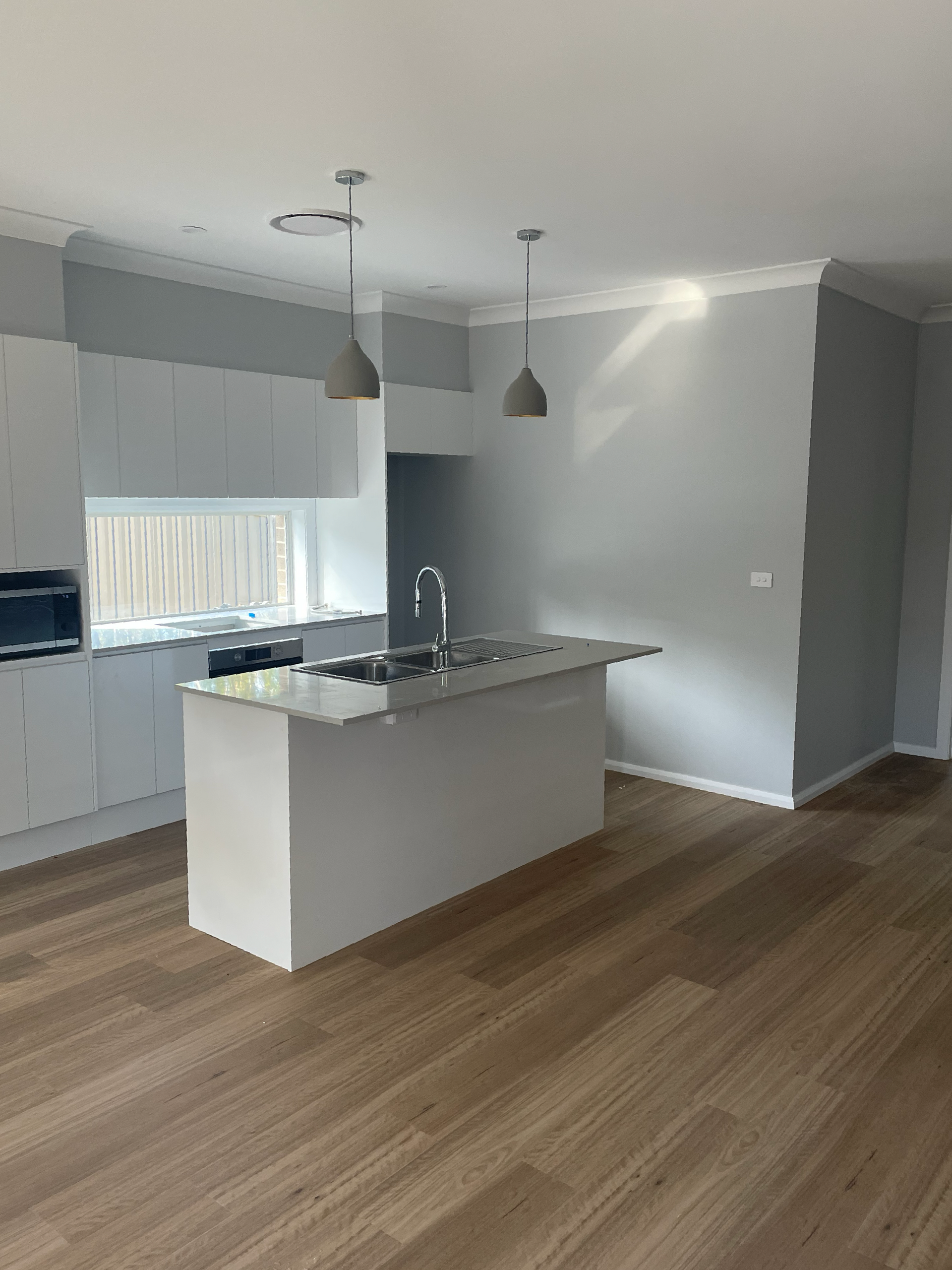 A kitchen with a large island in the middle of the room — D & J Saverino Painting & Decorating Pty Ltd In Fairy Meadow, NSW