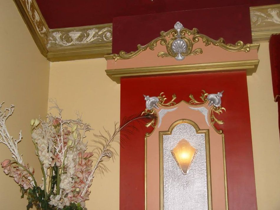A Vase of Flowers Sits in Front of a Red Wall — D & J Saverino Painting & Decorating Pty Ltd In Fairy Meadow, NSW