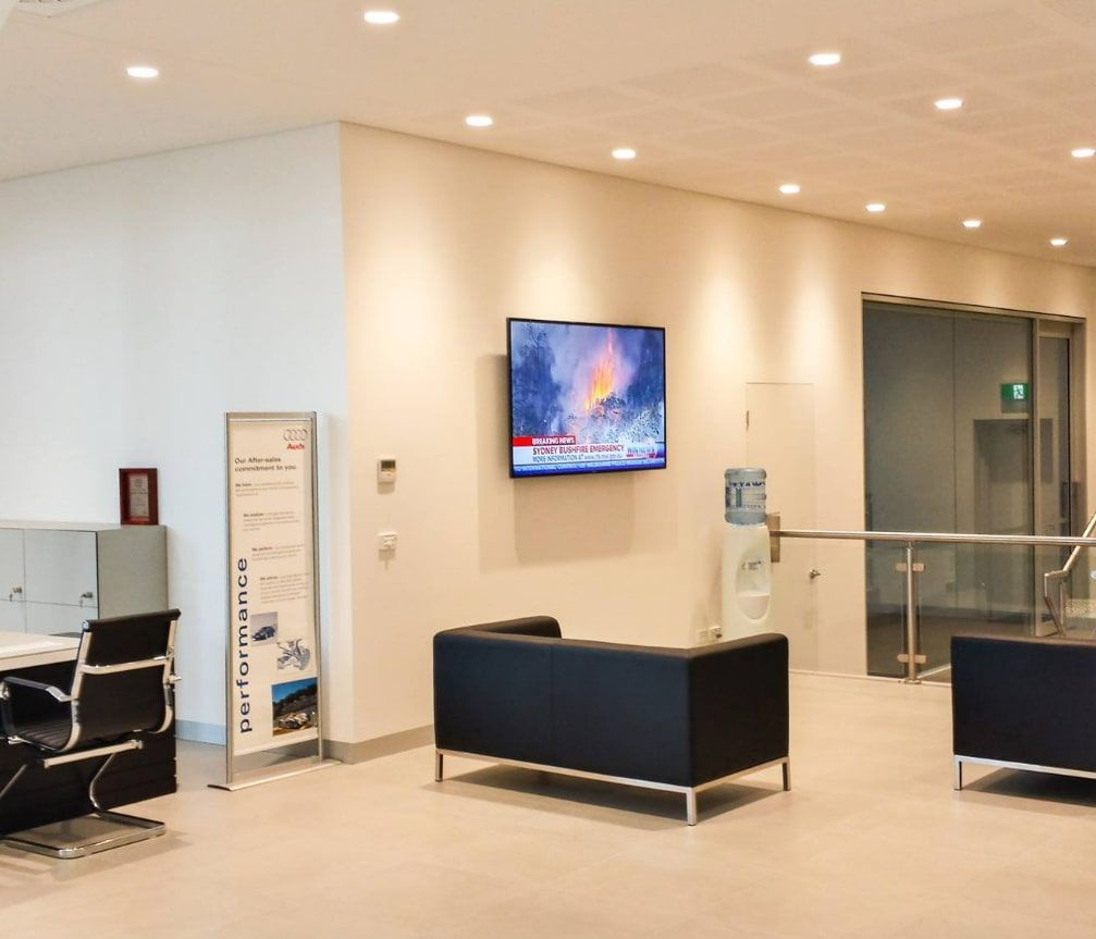 A Living Room With a Couch and a Television on the Wall — D & J Saverino Painting & Decorating Pty Ltd In Fairy Meadow, NSW