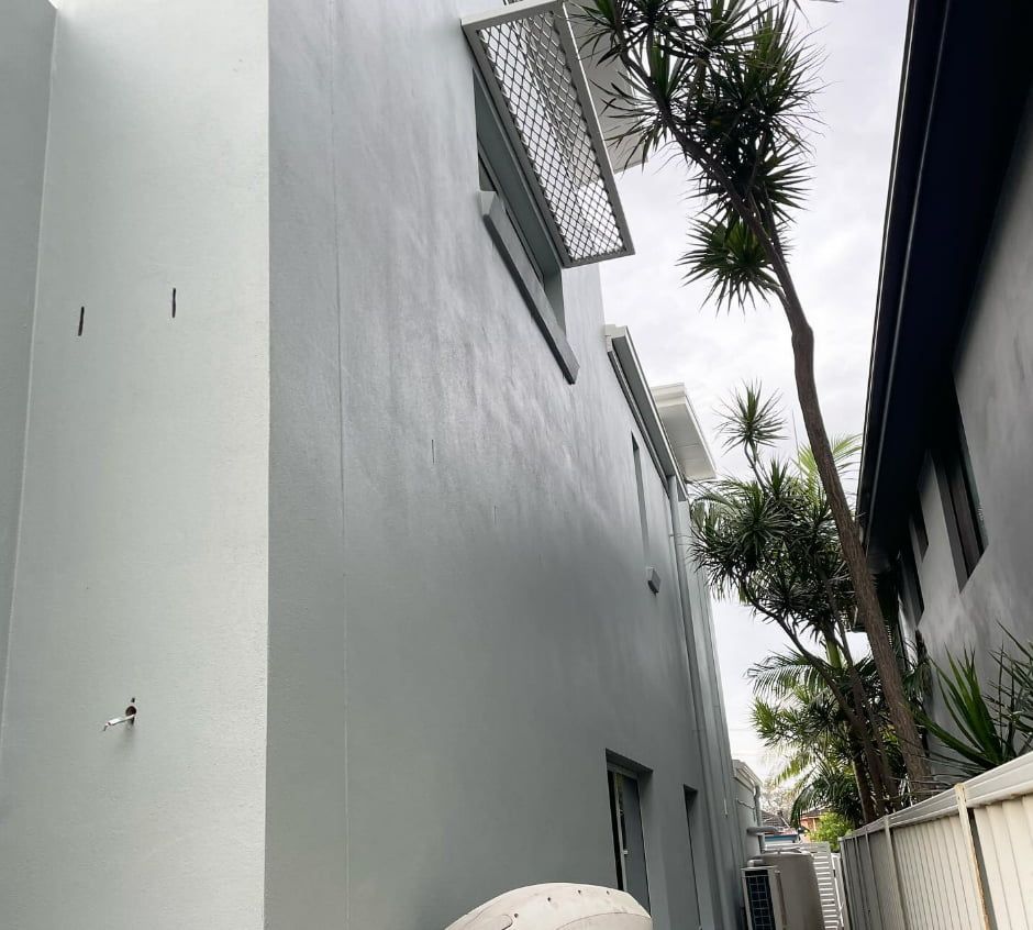 A White Building With a Palm Tree in the Background — D & J Saverino Painting & Decorating Pty Ltd In Fairy Meadow, NSW