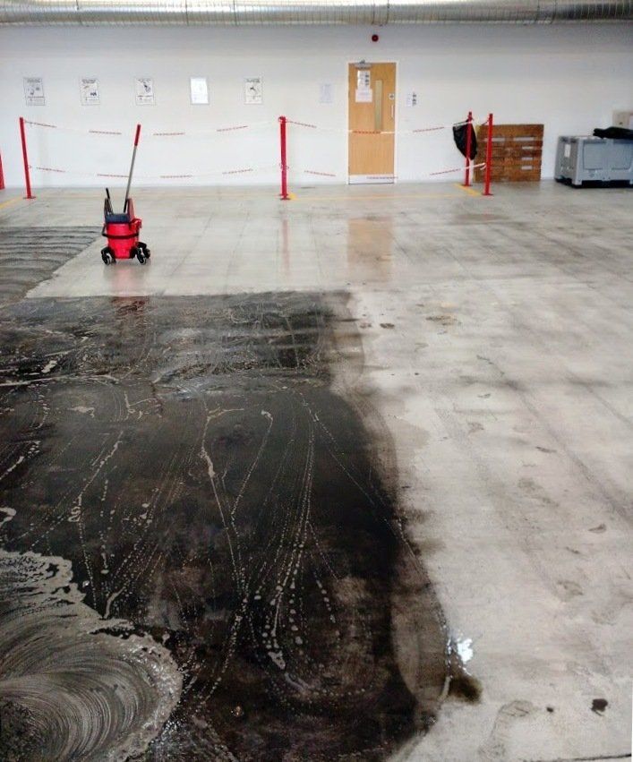 A dirty concrete floor with a red mop on it