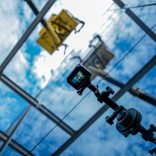 Looking up at a camera with a blue sky in the background