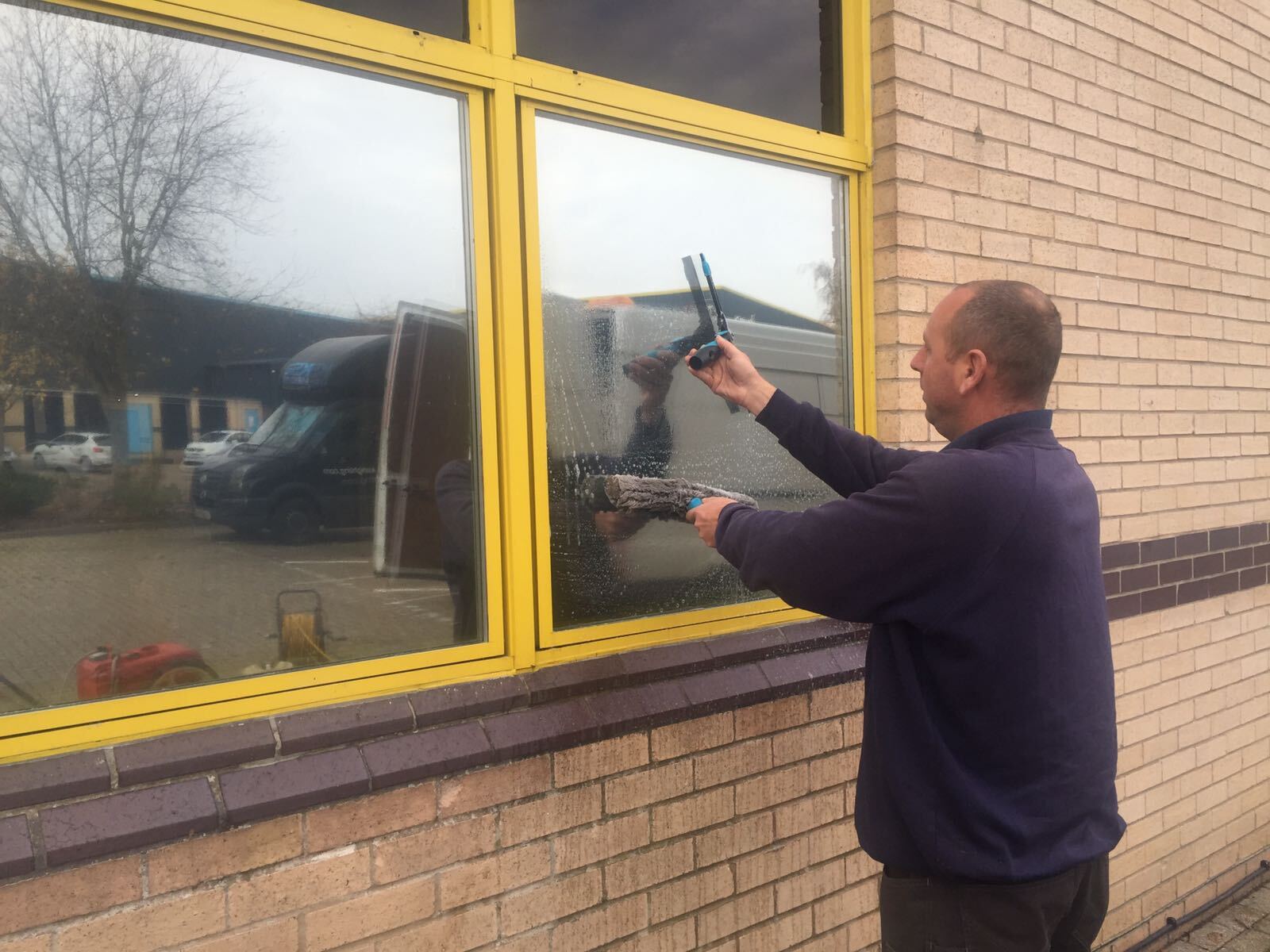 A man is cleaning a window with a drill.