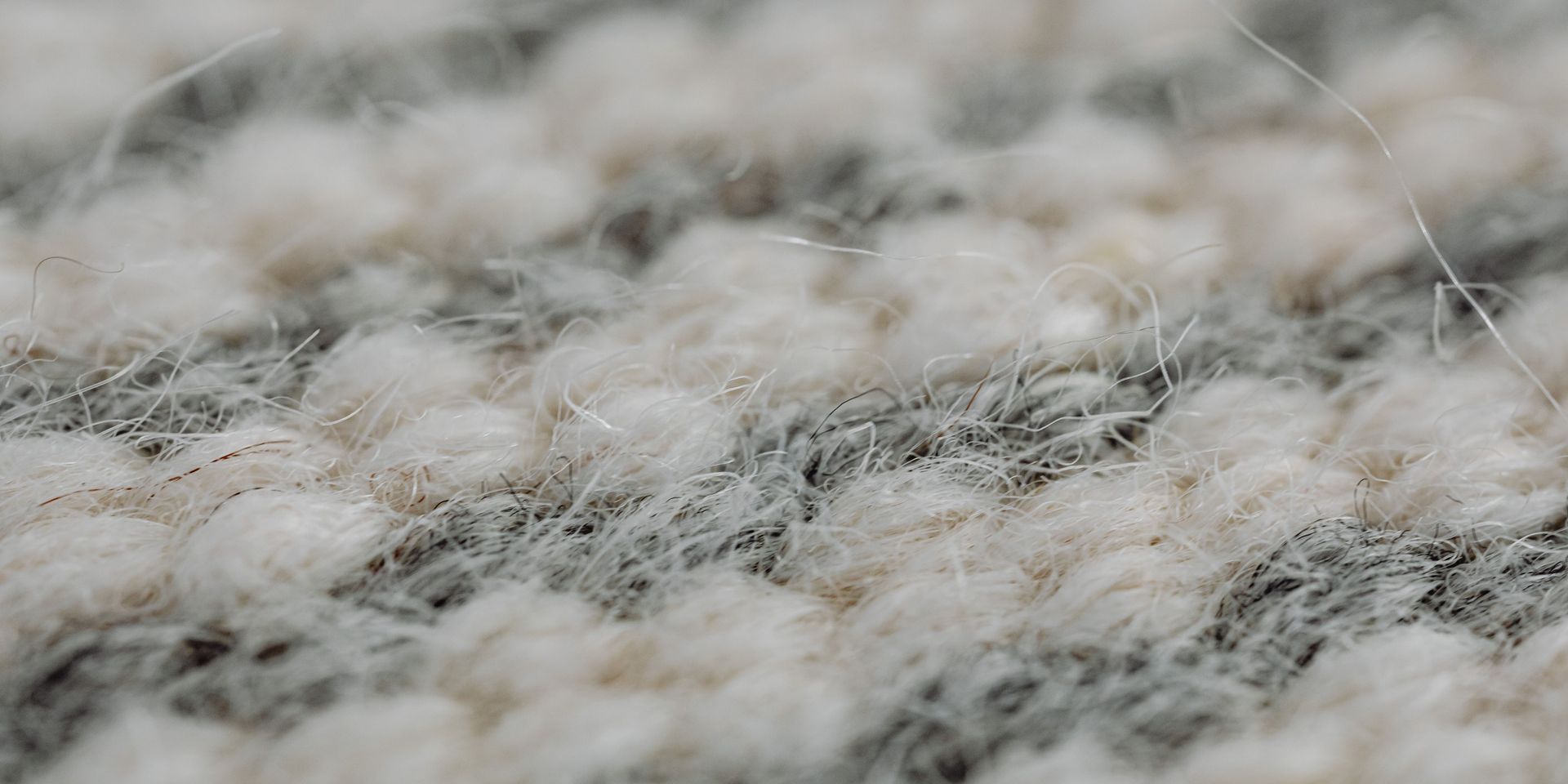 Close-up of a textured carpet with alternating bands of white and gray.