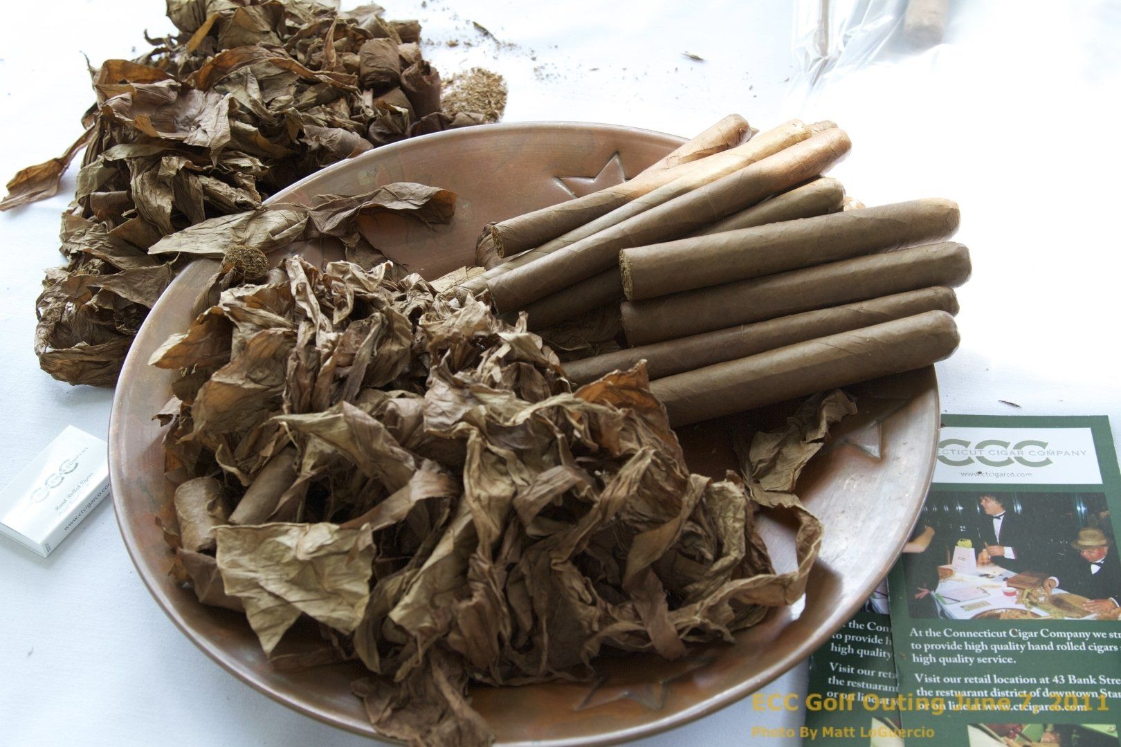 a plate of tobacco leaves and cigarettes on a table