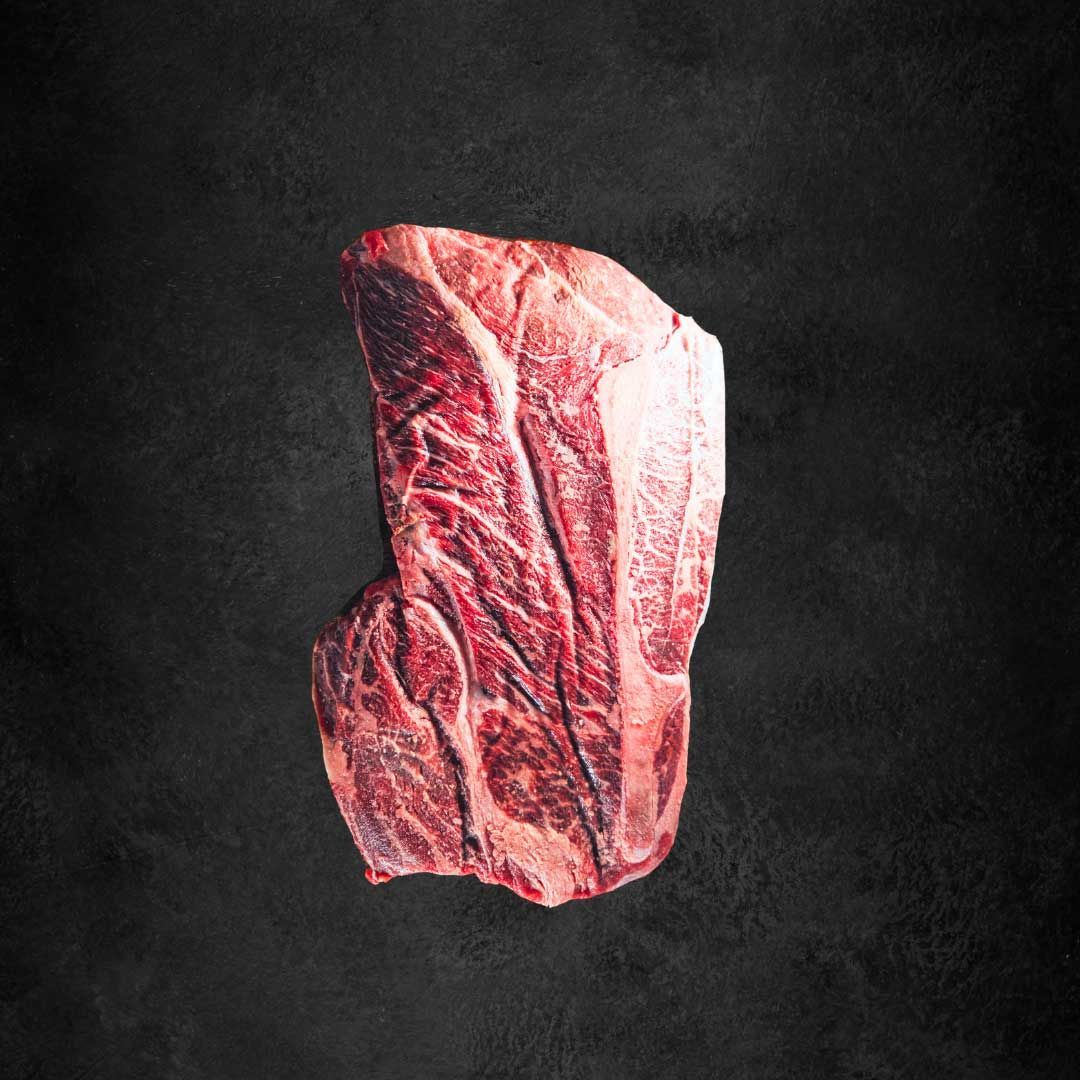 A piece of american wagyu meat is sitting on a black surface.