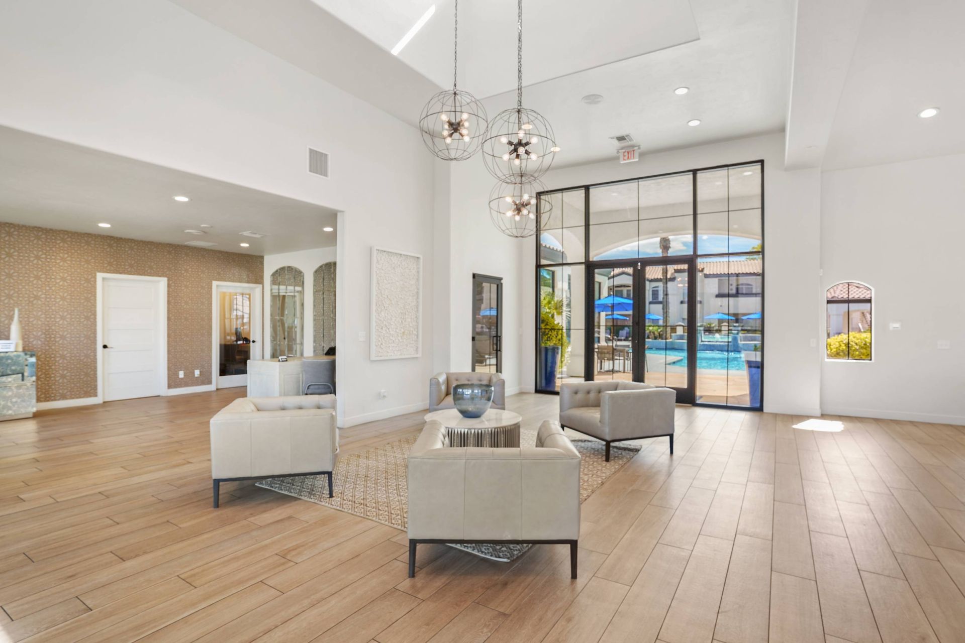 Bright apartment lobby with beige seating and glass doors to the outdoor pool.