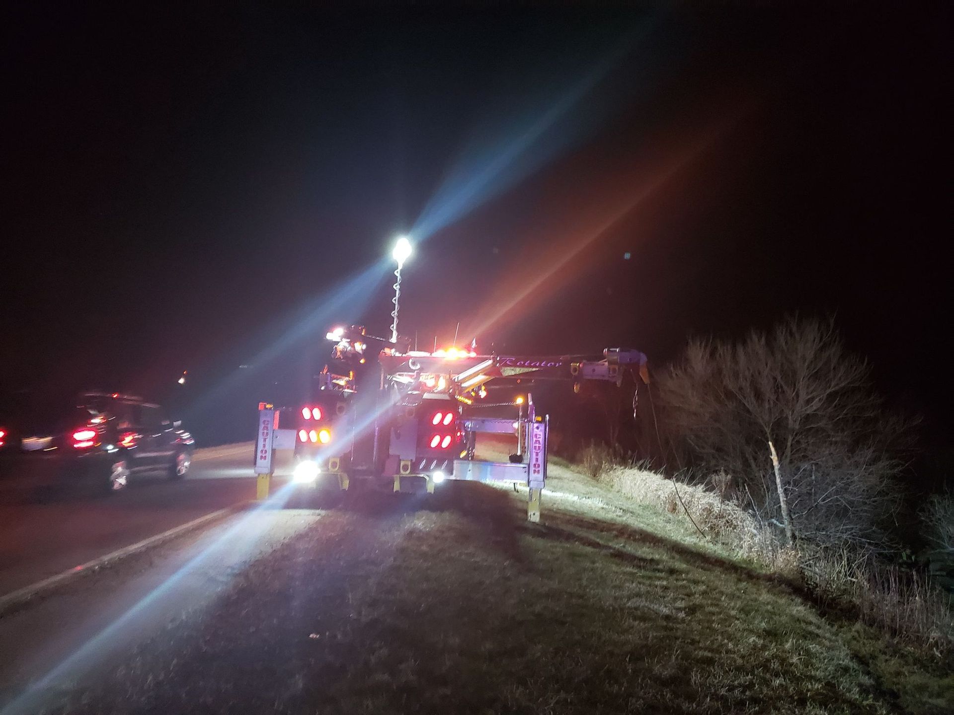 A fire truck is parked on the side of the road at night.