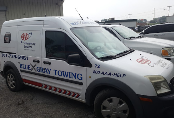 A white van that says blue gray towing on the side