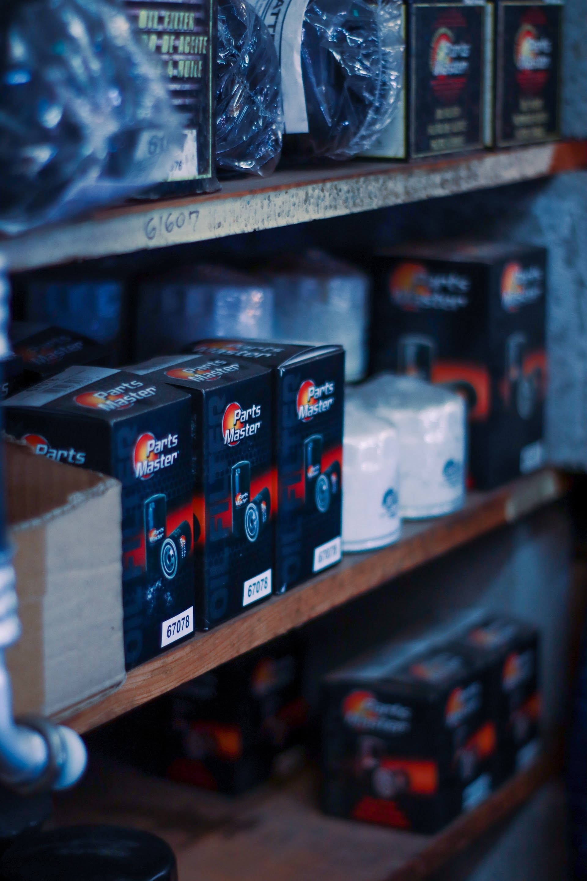 Shelves stocked with tractor parts in boxes and cylindrical filters | Lowry Auto Service