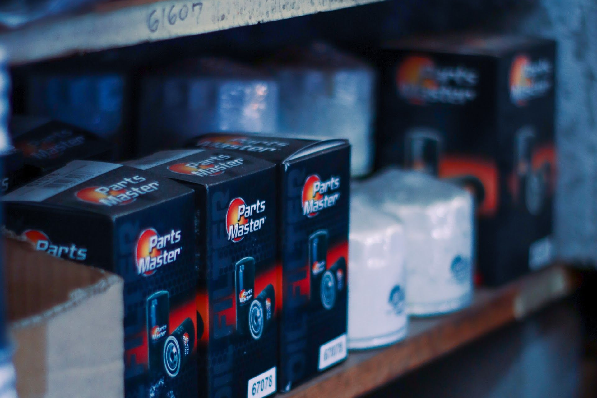 Parts Master oil filters on a shelf. Black boxes with red logos and white filter canisters | Lowry Auto Service