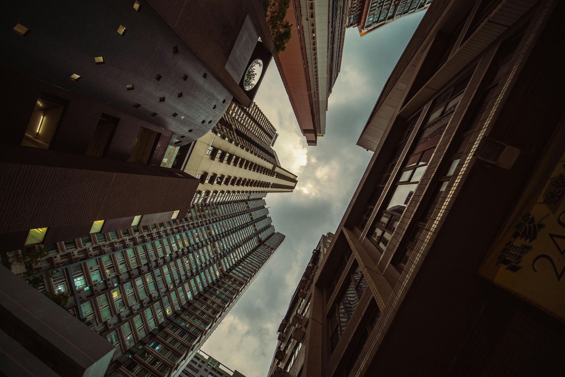 Skyscrapers viewed from below, against a cloudy sky. | Hong Kong Annuity