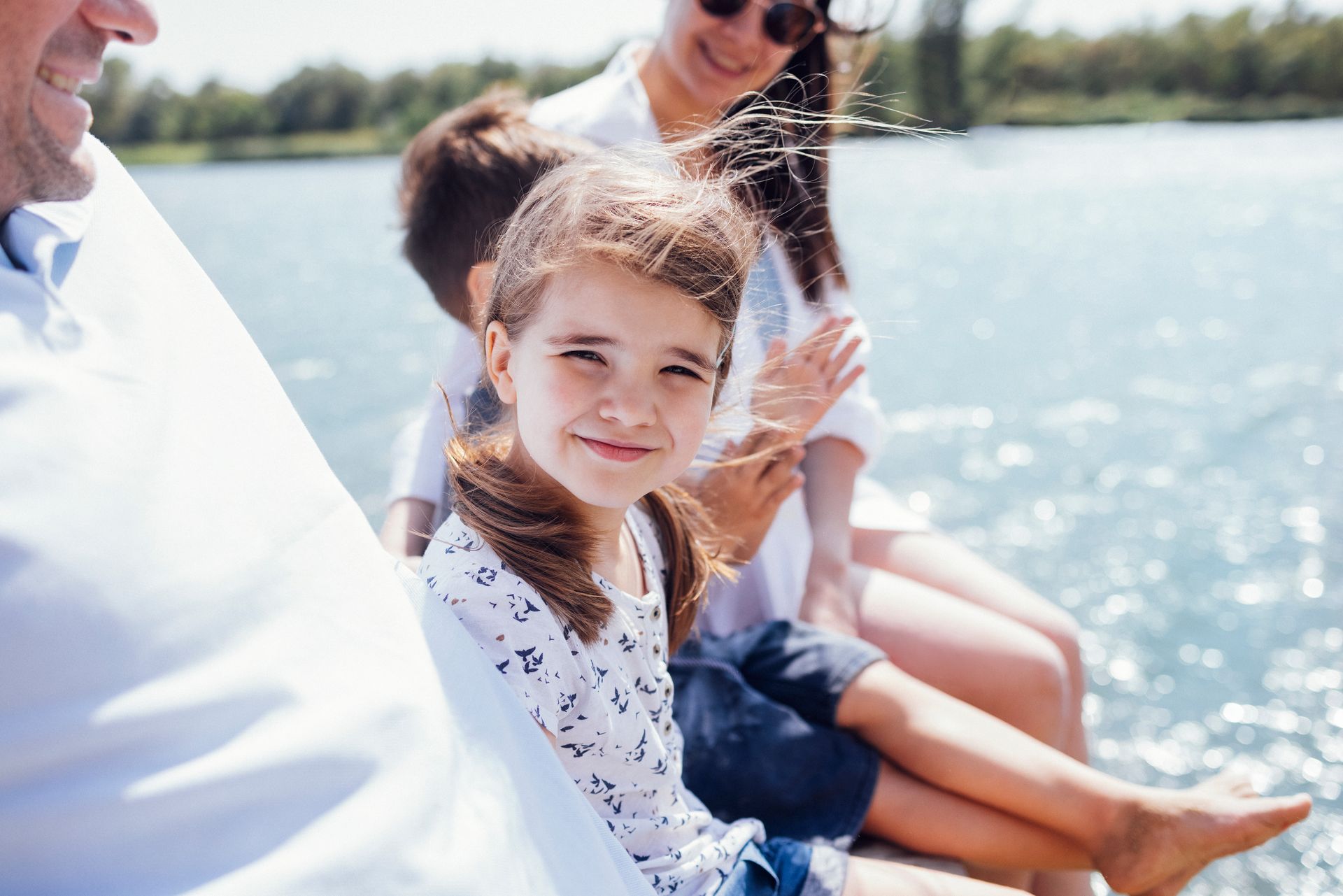 A family is sitting on a boat in the water.