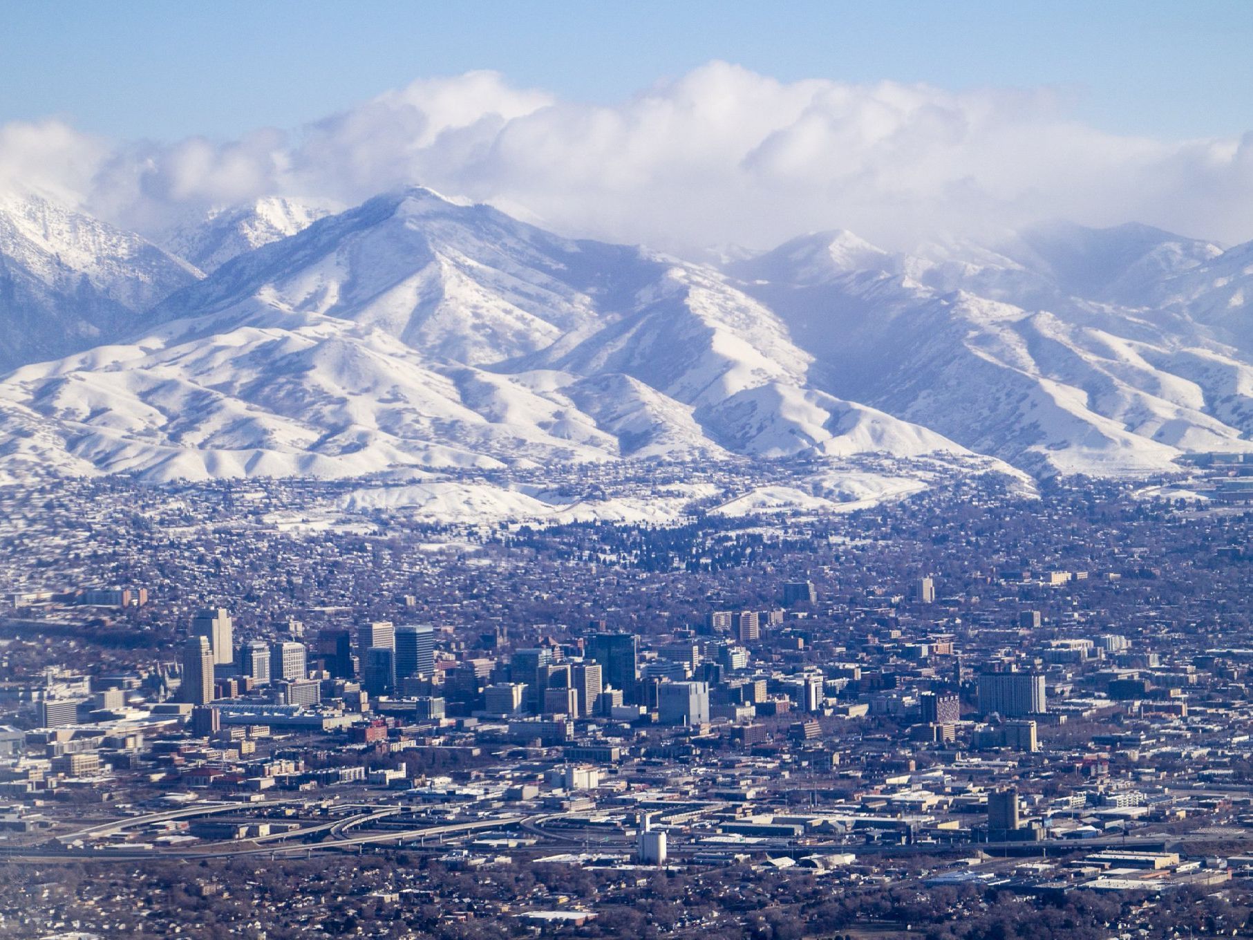 An aerial view of a city with mountains in the background