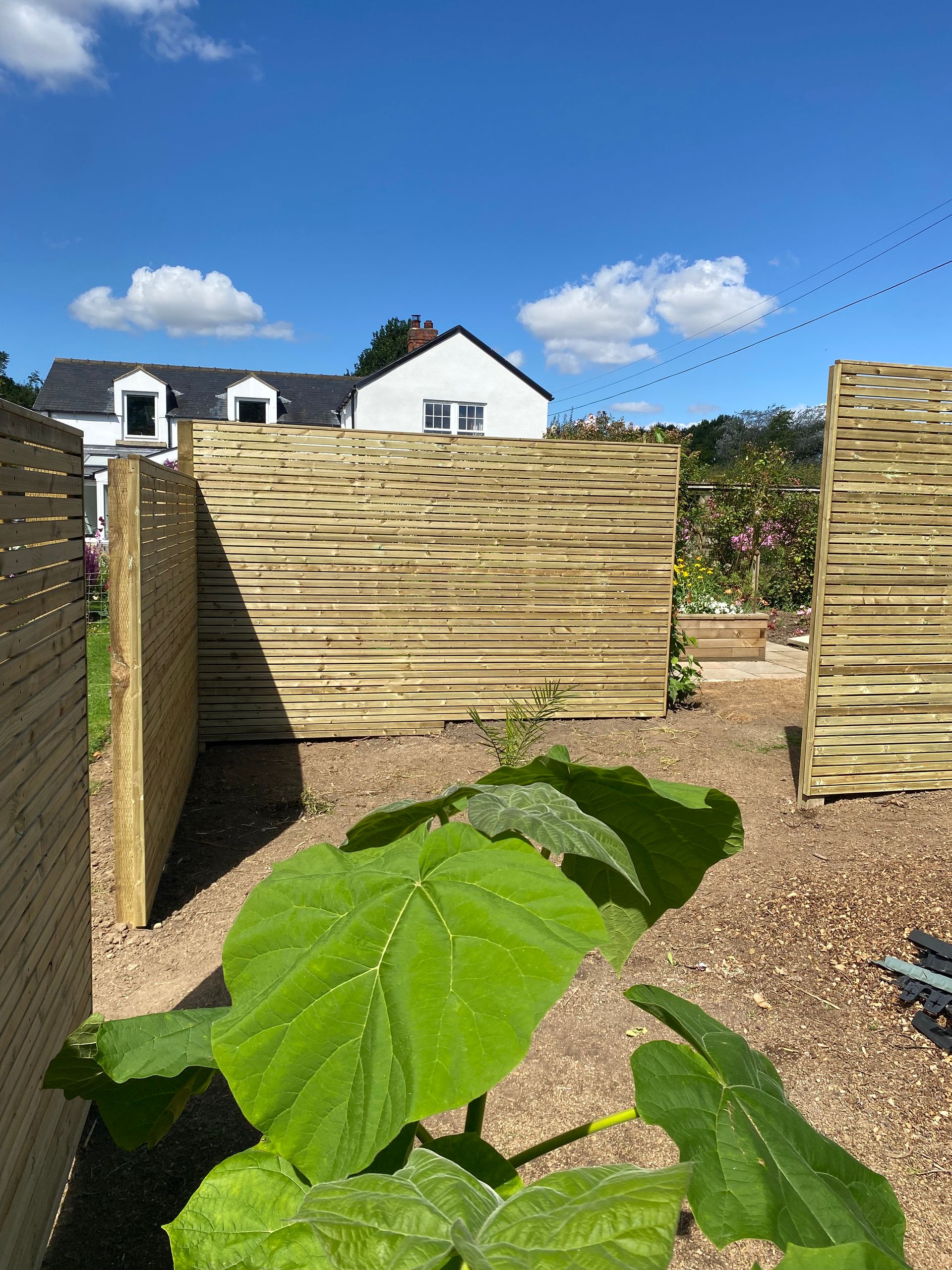 Wooden garden fencing in a garden on a sunny day.