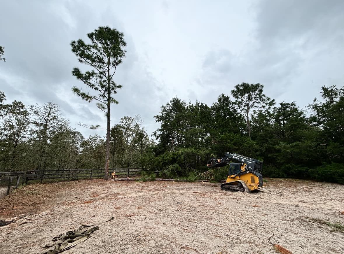 A bulldozer is sitting in a field with trees in the background.