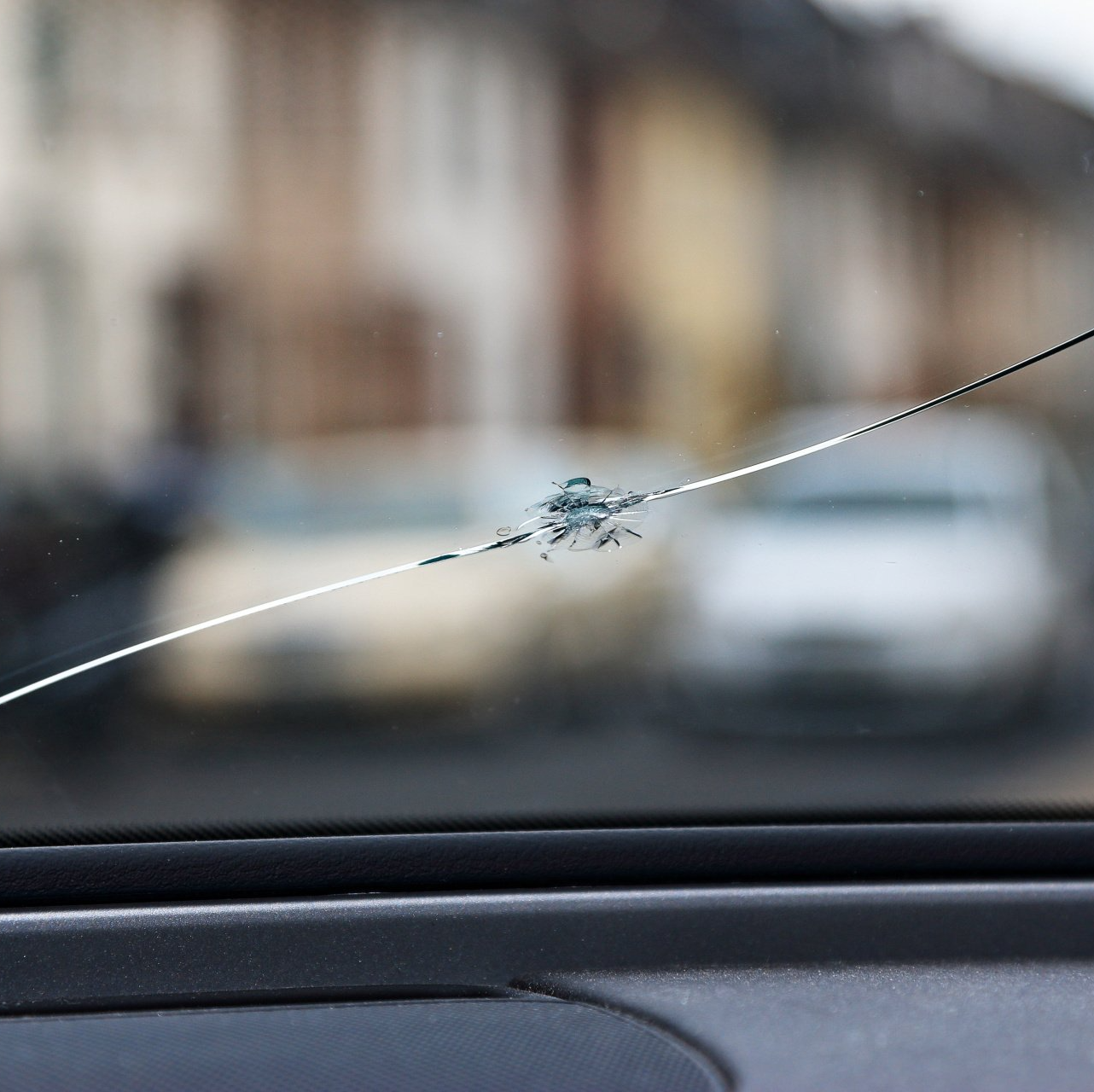 Eine Nahaufnahme einer gesprungenen Windschutzscheibe eines Autos.