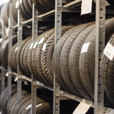 Eine Reihe von Reifen sind auf Regalen in einem Lager gestapelt