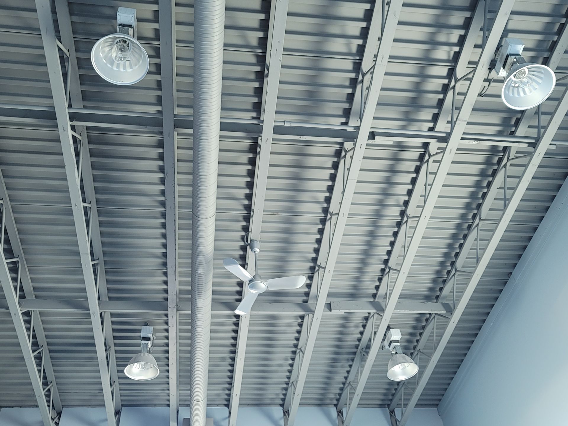 A ceiling with a ceiling fan and lights hanging from it.