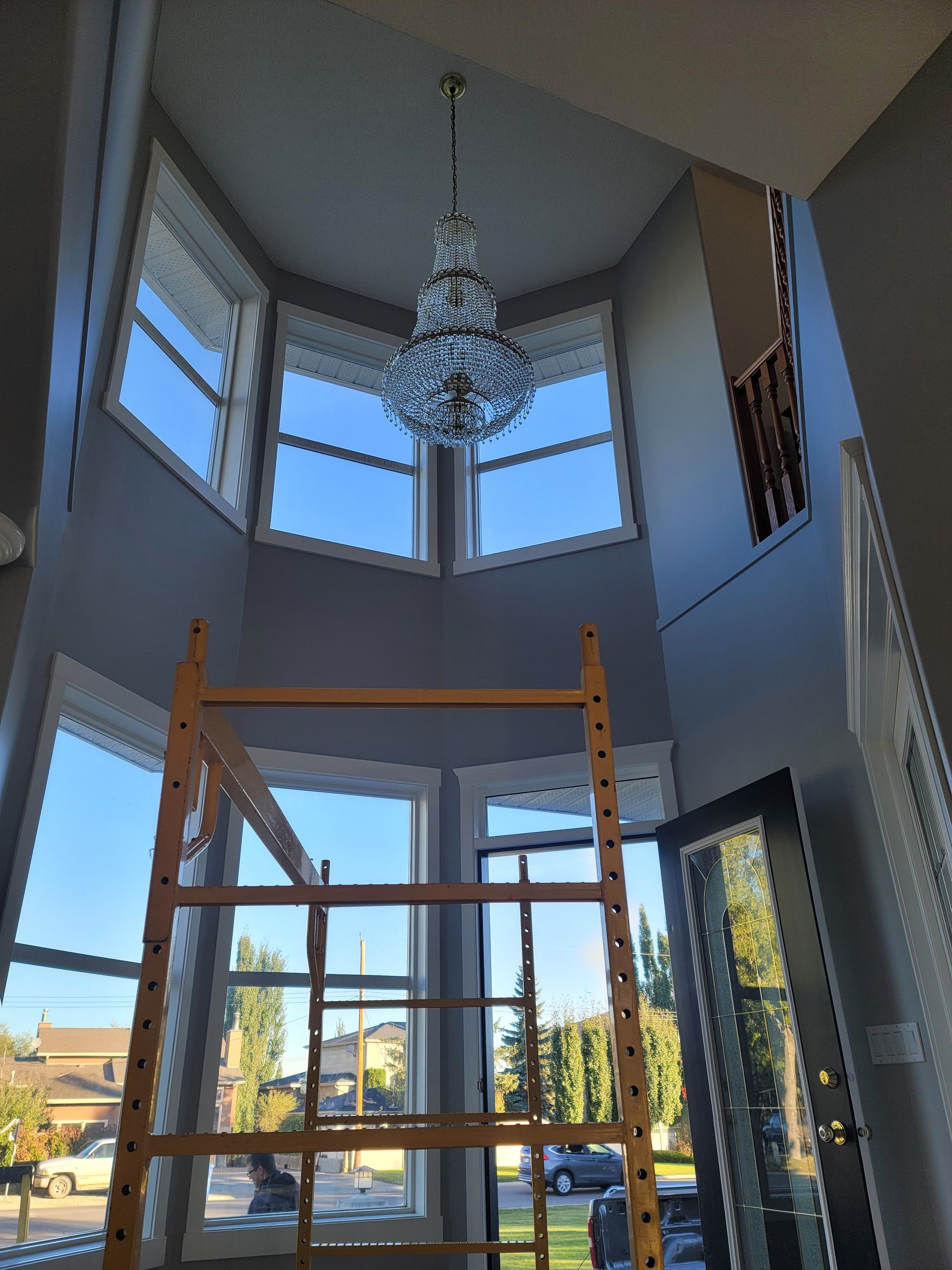 A large room with a lot of windows and a chandelier hanging from the ceiling.
