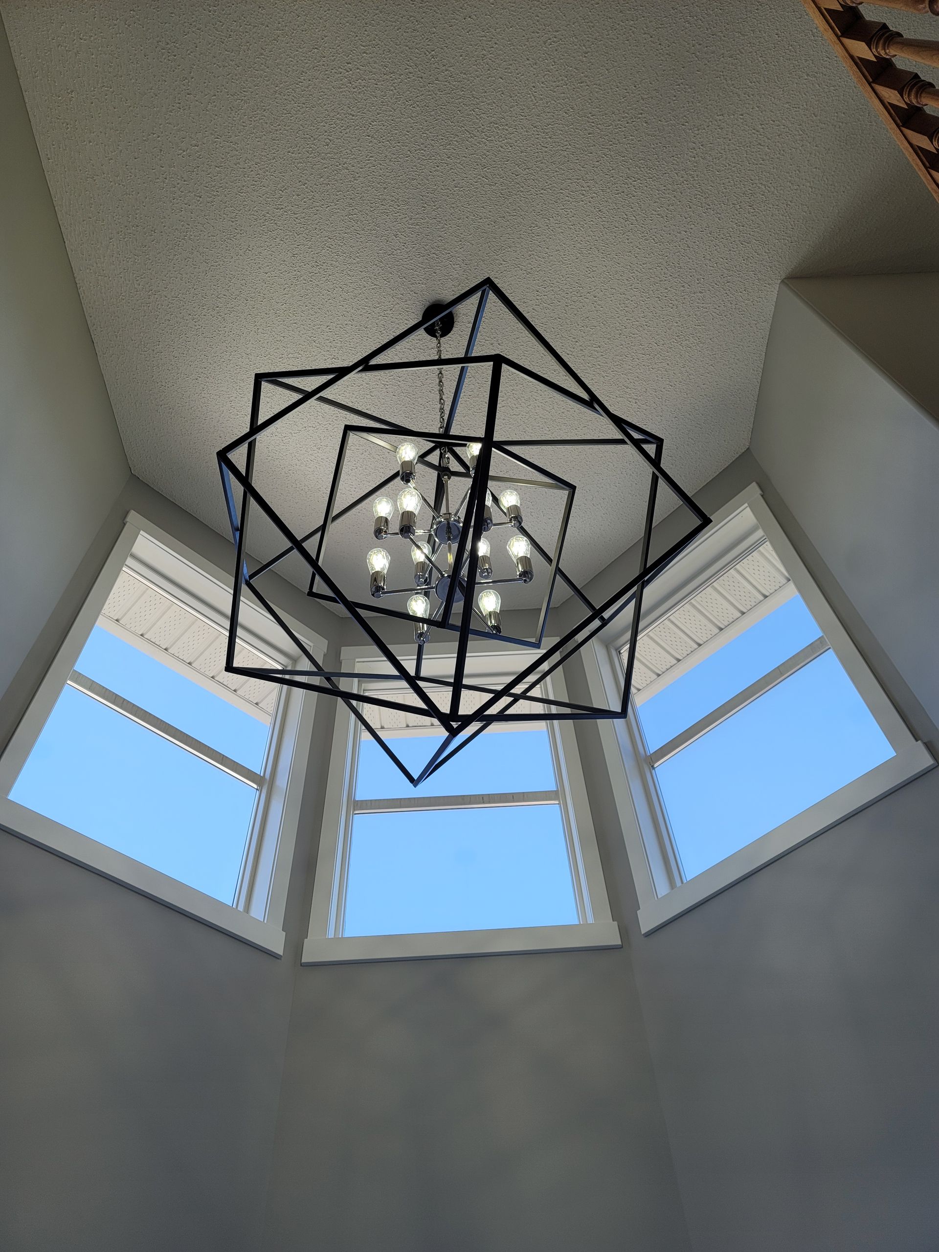 A chandelier is hanging from the ceiling in front of a window