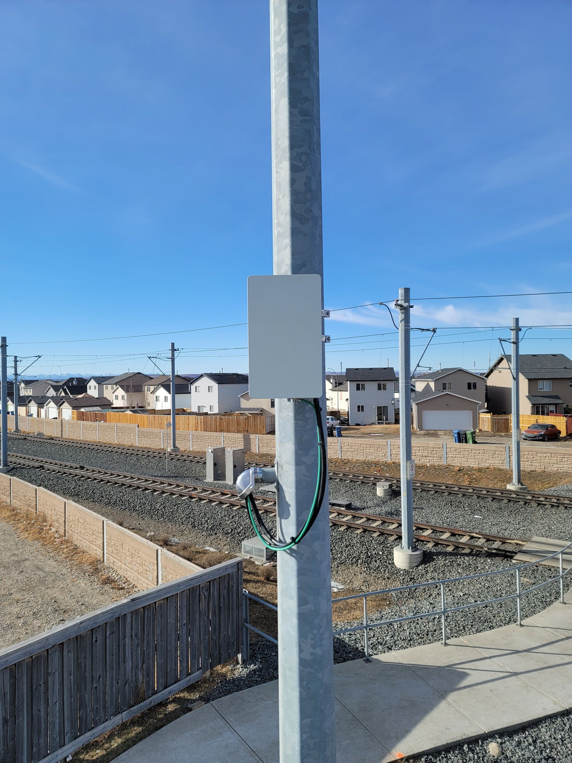 A pole with a box attached to it in a residential area.