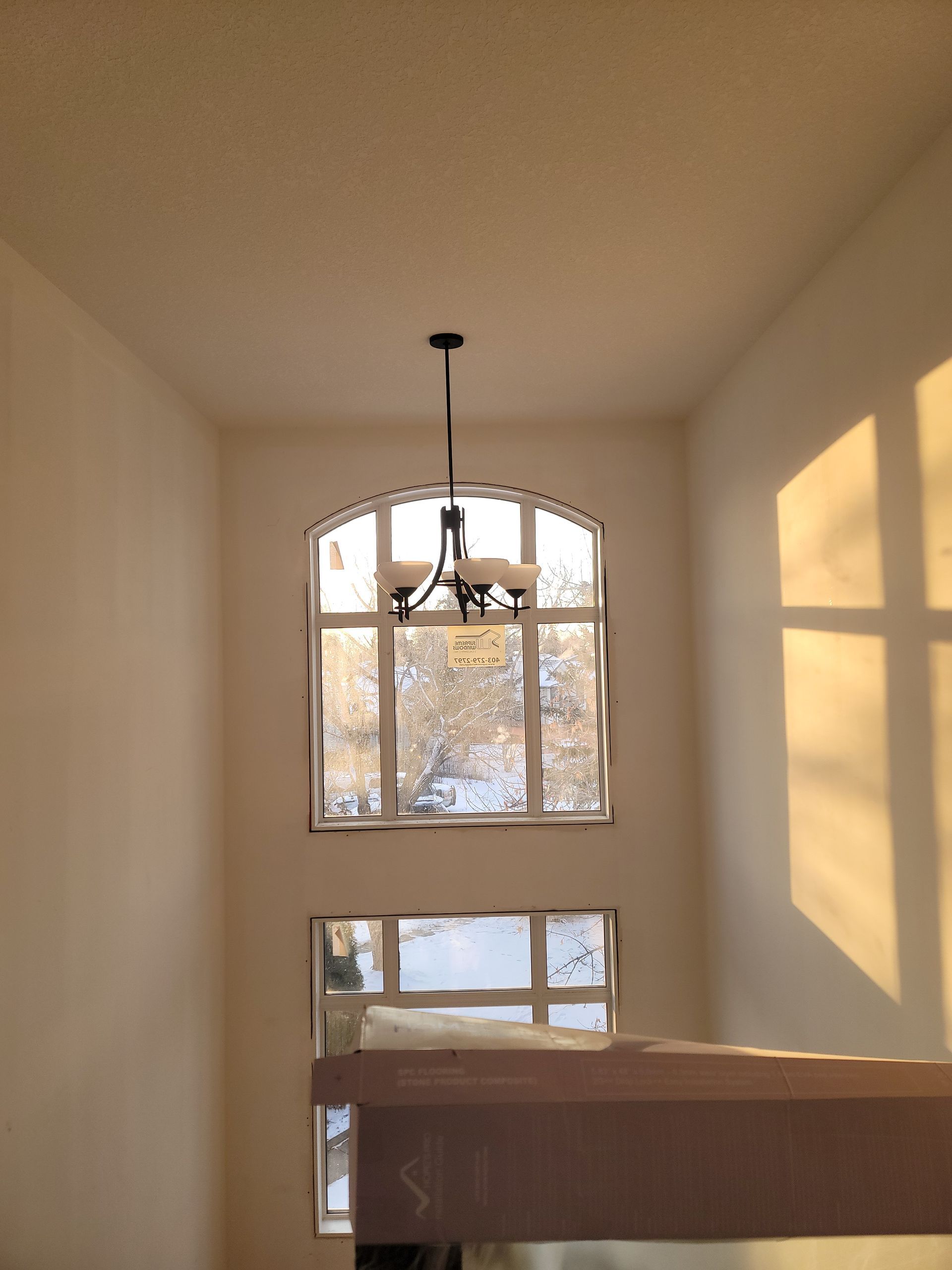 A large window with a chandelier hanging from the ceiling