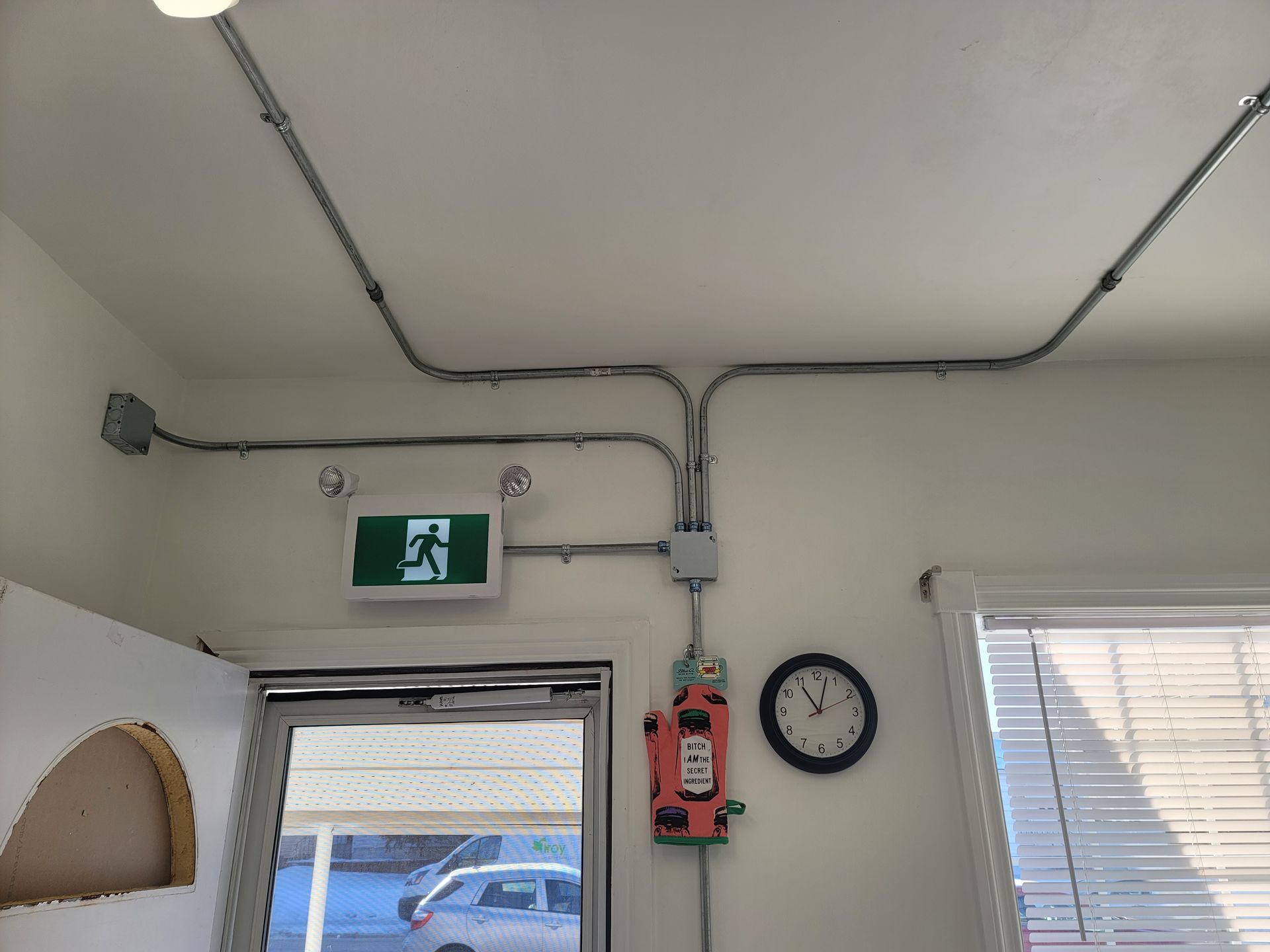 A room with a clock and a exit sign on the wall.