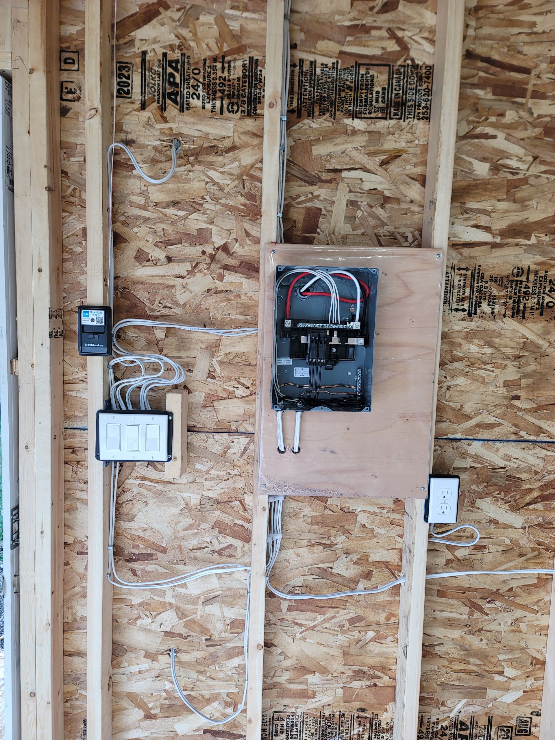 A wooden wall with a electrical box on it.