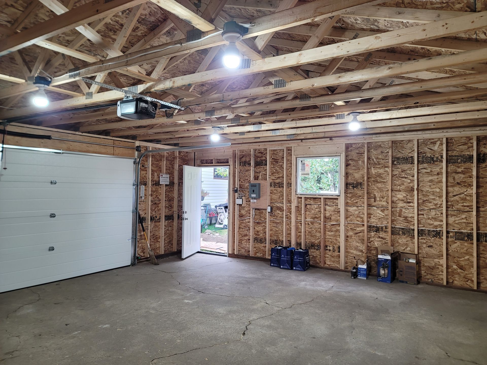 A garage under construction with a white garage door and a window.
