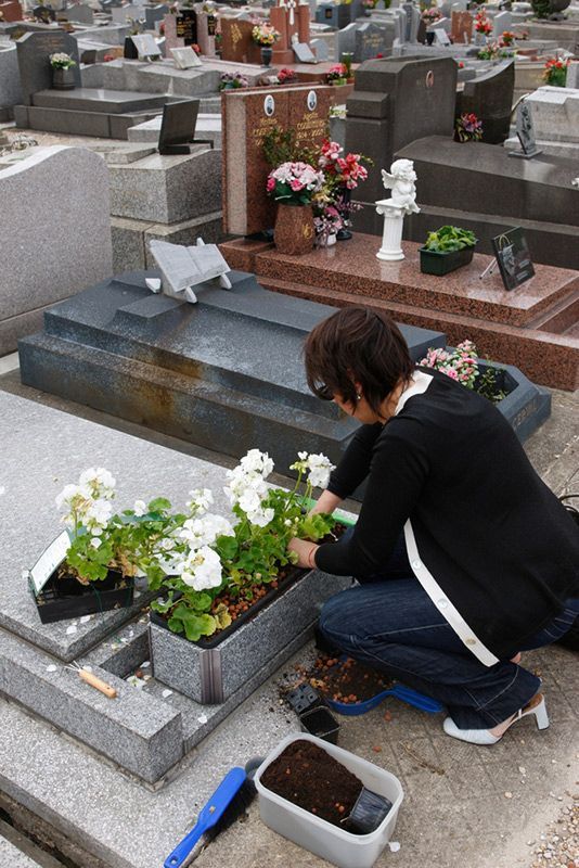 Woman Is Kneeling Down In Front Of A Grave Planting Flowers — Northern Rivers Headstones in Tenterfield, NSW