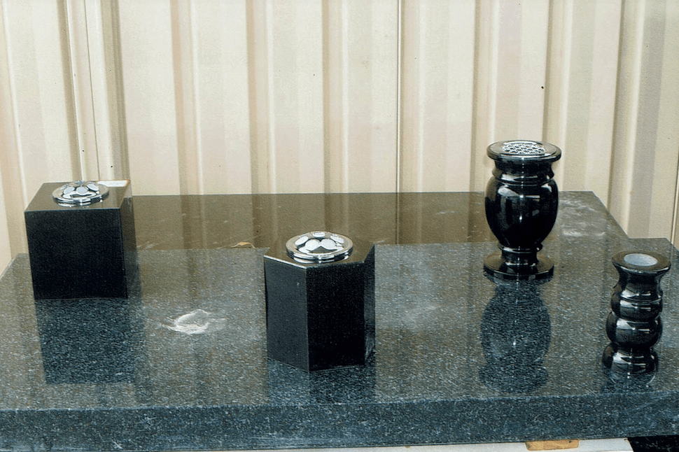 Three Black Vases Are Sitting On A Black Table — Northern Rivers Headstones in Casino NSW