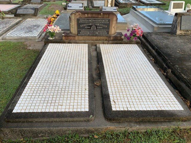A Couple Of Graves In A Cemetery With Flowers On Them — Northern Rivers Headstones in Casino NSW