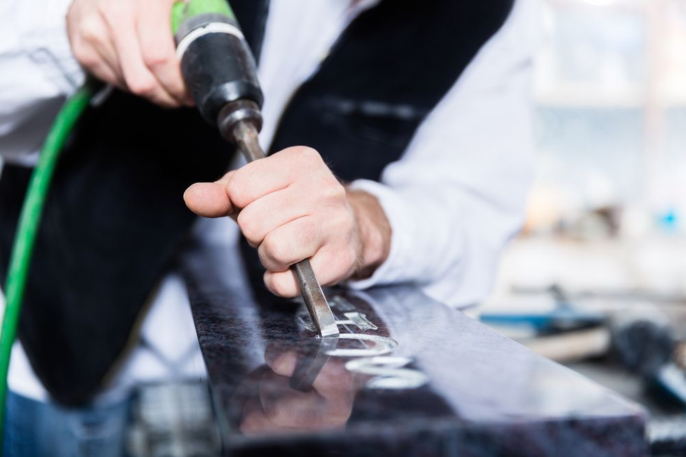Man Is Using A Drill To Drill A Hole In A Piece Of Glass — Northern Rivers Headstones in Kyogle, NSW