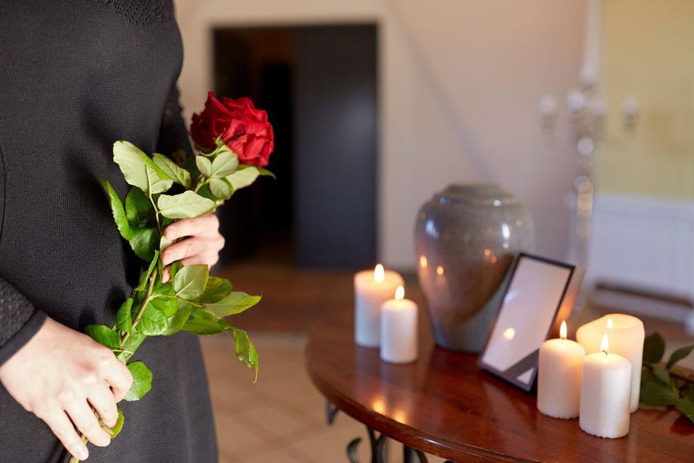 Woman Is Holding A Red Rose In Front Of A Table With Candles— Northern Rivers Headstones in Maclean, NSW
