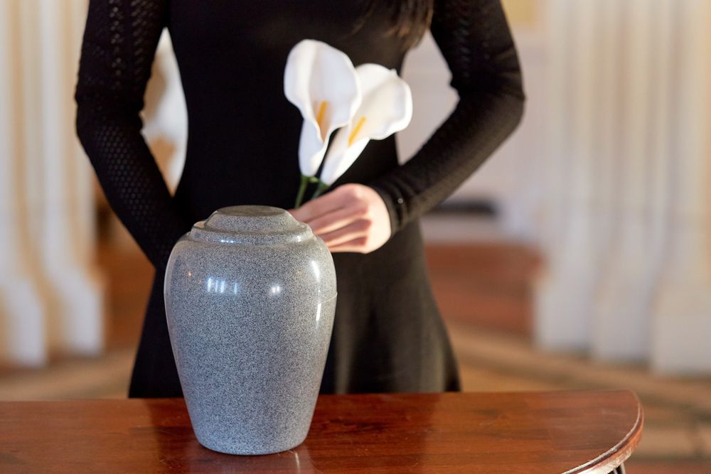 Woman Is Holding Flowers In A Vase On A Table — Northern Rivers Headstones in Maclean, NSW