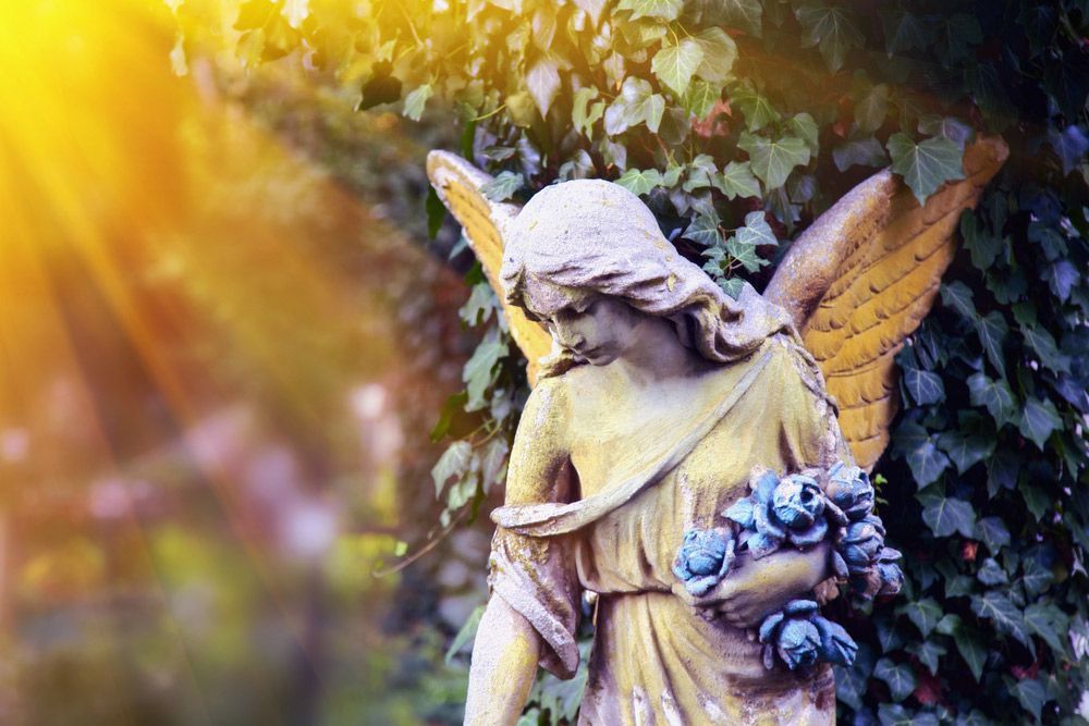 Statue Of An Angel Holding A Bouquet Of Flowers In A Cemetery — Northern Rivers Headstones in Kyogle, NSW