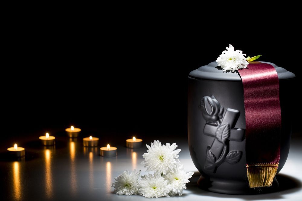 Black Urn With Flowers And Candles On A Table — Northern Rivers Headstones in Grafton, NSW