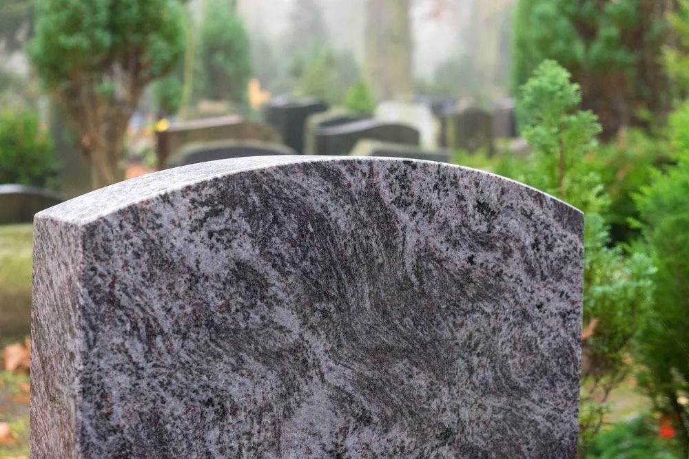 Close-up of a Gray Granite Headstone in Cemetery