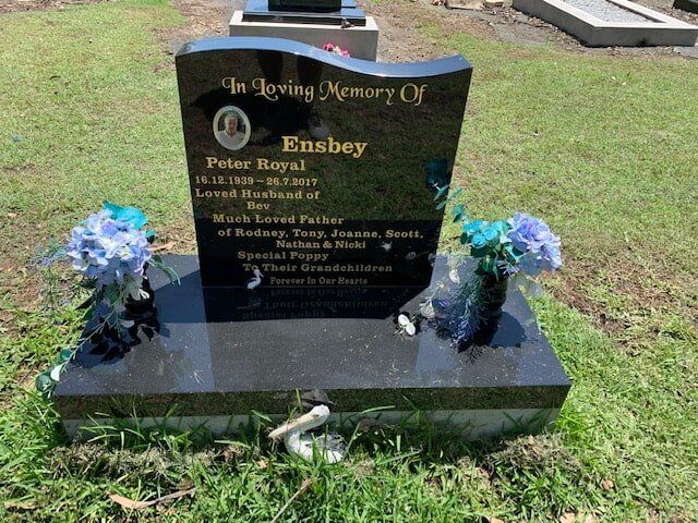 A Gravestone In A Cemetery With Flowers On It — Northern Rivers Headstones in Casino NSW