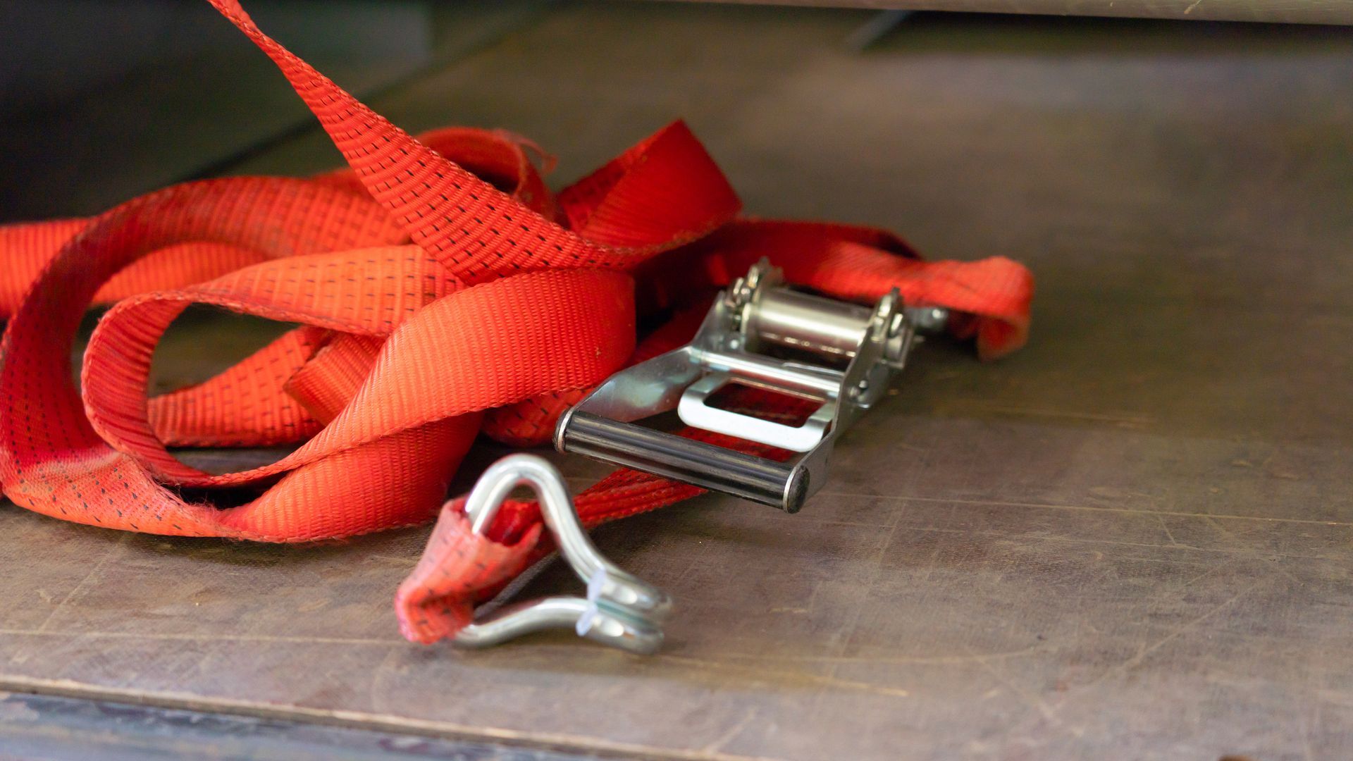 A red lashing strap thrown onto the floor of a truck body