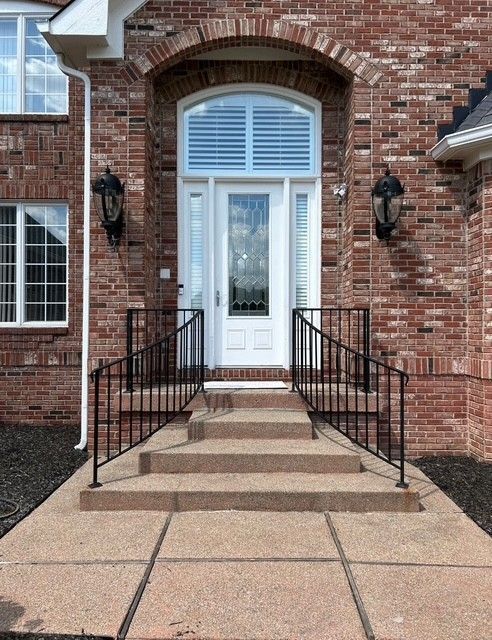 A brick house with a white door and stairs