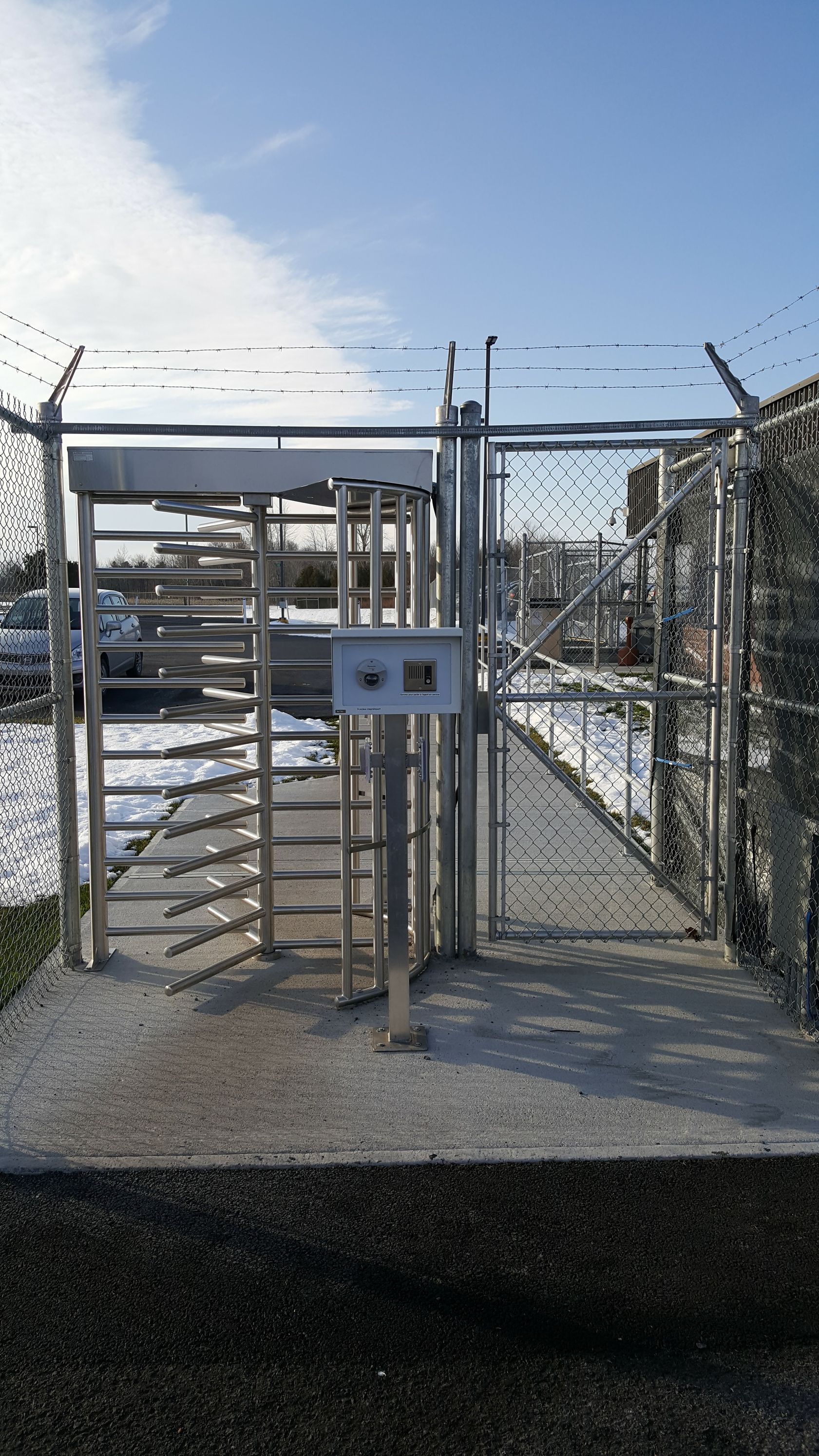 Un tourniquet avec une clôture en fil de fer barbelé en arrière-plan.