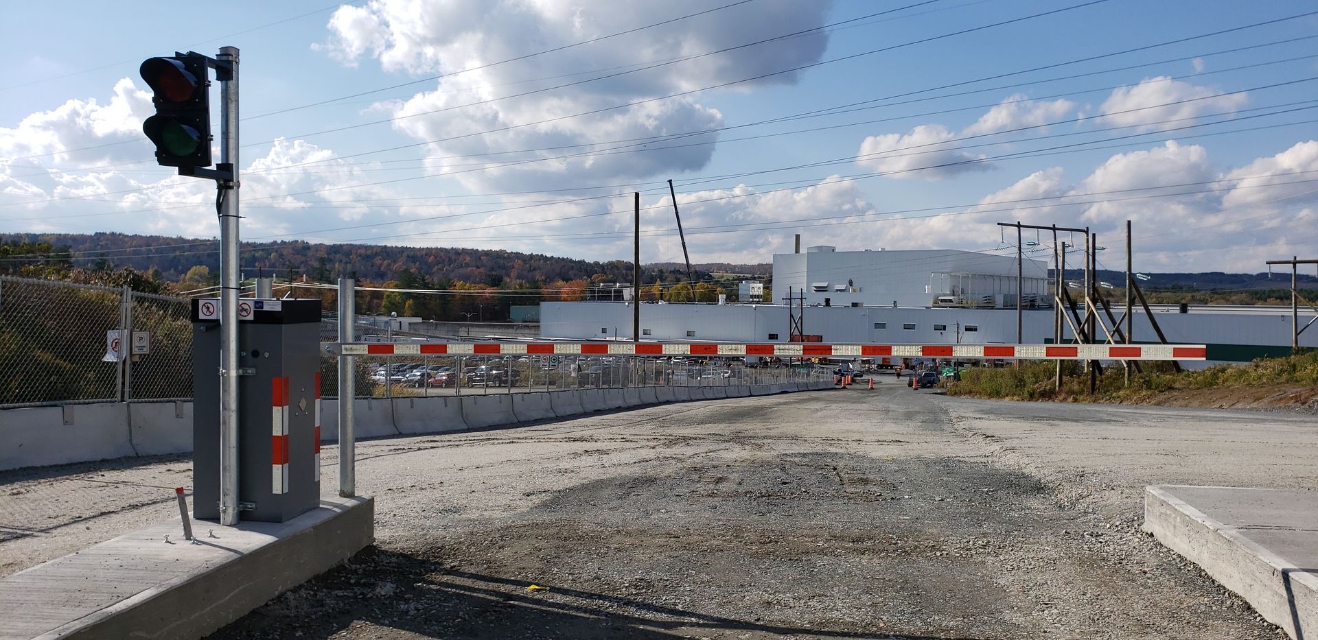 Un passage à niveau avec un feu rouge et une barrière.